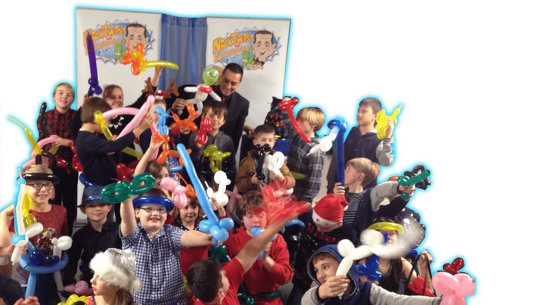 Nick Twist and the children having fun with balloons and magic.